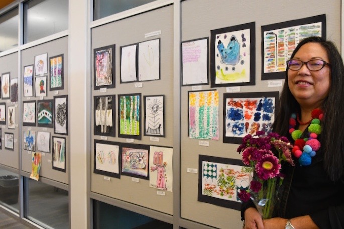 Female holding flowers with artwork in background