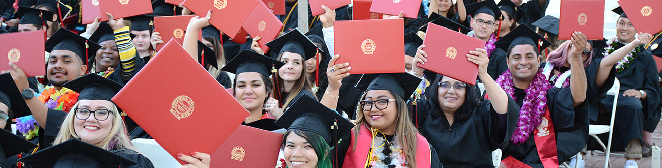 Group of graduates holding degrees