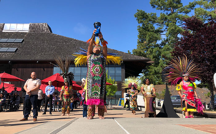 Indigenous dancer and two male foothill employees