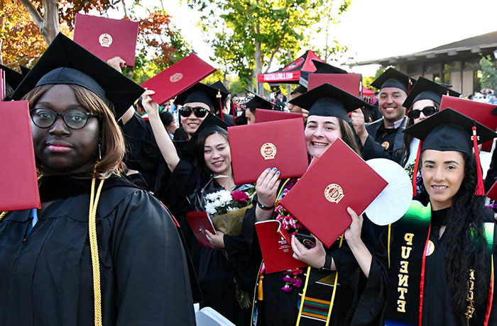 group of student graduates holding degree covers