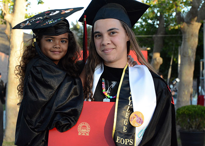 Female graduate holding young daughter